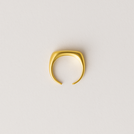 Gold ring on a light gray background