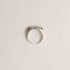 Silver ring on a light beige textured background
