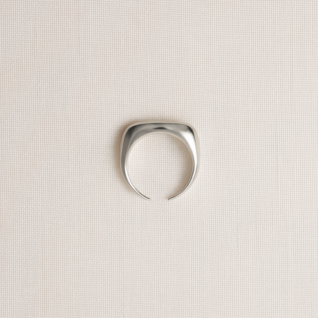 Silver ring on a light beige textured background